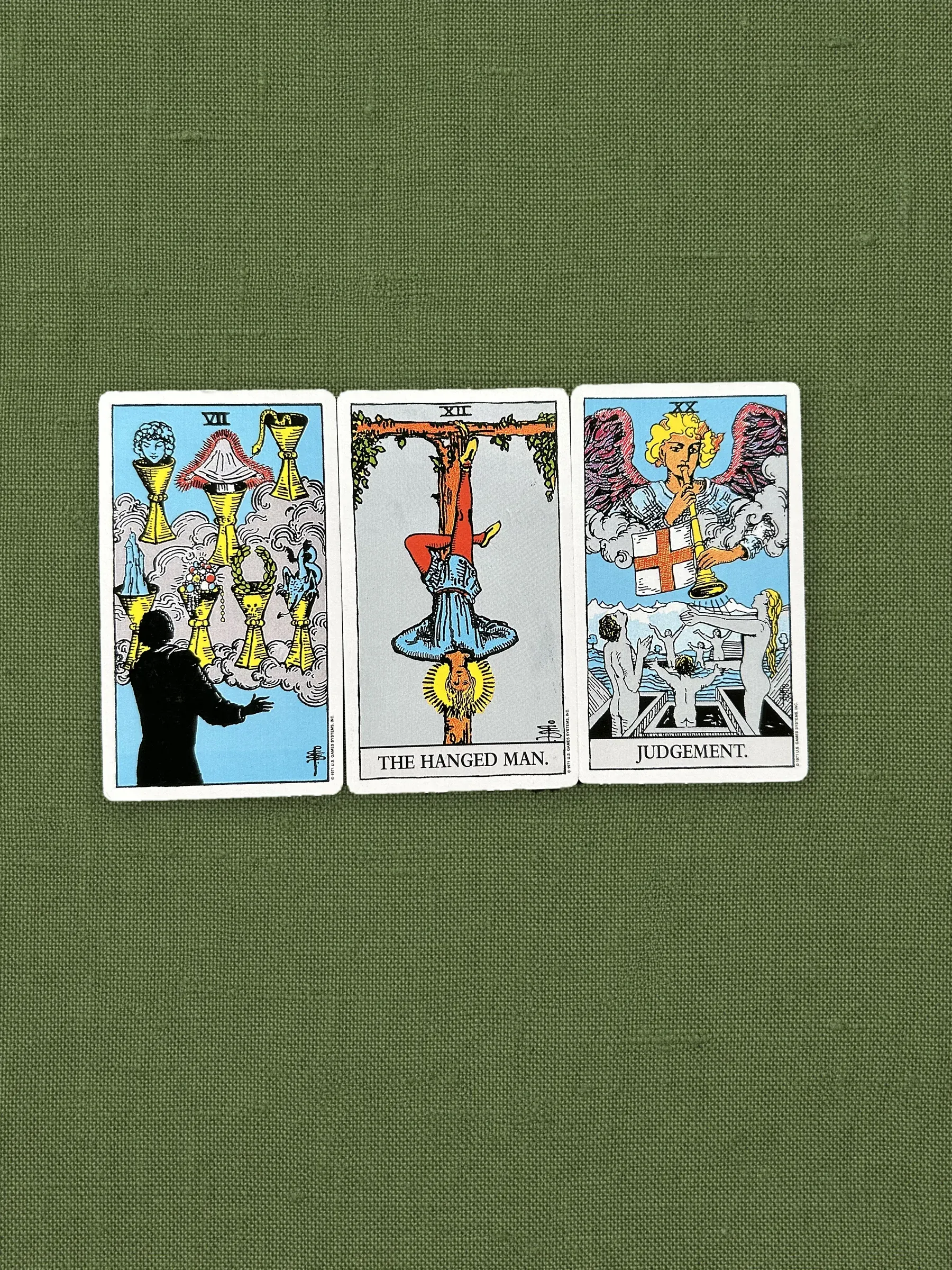 Three cards on olive linen — the base of every reading